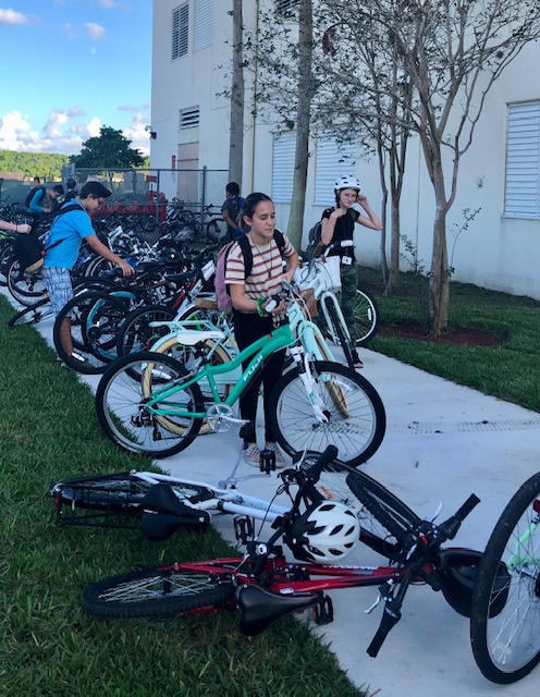 Students+getting+ready+to+ride+their+bikes%2C+some+wearing+helmets+some+not.+